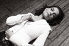 Katie Holmes laying on rustic hardwood floor wearing Roberto Coin's "Primavera Cuff"