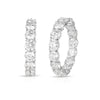 White gold earrings featuring large diamonds on the inside and outside of the hoop design on a white background