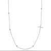 The Roberto Coin TINY TREASURES DIAMOND SLIVER CROSS AND STATION NECKLACE is a delicate white gold chain with a sparkling diamond cross and diamond bezel stations, offering minimalist elegance that stands out against any plain backdrop.