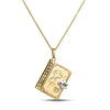 Yellow and white gold necklace showing cover of book pendant featuring a ruby on a white white background
