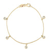 Yellow gold bracelet with five dangling diamond stations on a white background