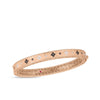 The Roberto Coin VENETIAN PRINCESS BLACK AND WHITE DIAMOND SATIN BANGLE in 18K rose gold showcases alternating black and white floral motifs, a patterned inner band, sparkling diamonds, and a red gem accent.