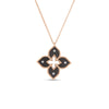 The VENETIAN PRINCESS DIAMOND AND TITANIUM SMALL FLOWER NECKLACE by Roberto Coin features a gold chain and a four-petal floral pendant with black enamel, diamond accents on each petal, and a textured gold outline.