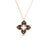 The VENETIAN PRINCESS DIAMOND AND TITANIUM SMALL FLOWER NECKLACE by Roberto Coin features a gold chain and a four-petal floral pendant with black enamel, diamond accents on each petal, and a textured gold outline.