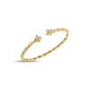 Yellow gold twist bangle with diamond flower ends on a white background