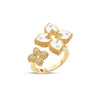 Side view of yellow gold and white enamel flower ring with diamond accents on a white background