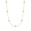 Yellow gold necklace with mother of pearl flower stations on a white background
