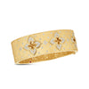 The VENETIAN PRINCESS DIAMOND AND SATIN FINISH FLOWER WIDE BANGLE by Roberto Coin features floral motifs with sparkling diamonds set on brushed 18K yellow gold, ornate inner engraving, and diamond-accented details.