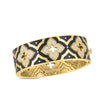 The VENETIAN PRINCESS DIAMOND AND ENAMEL WIDE FLOWER BANGLE by Roberto Coin is crafted in 18K yellow gold, featuring black enamel, diamond-studded floral motifs, a repeating pattern, and an intricate interior design.