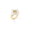 Side view of yellow gold and mother of pearl flower ring with diamond accents on a white background