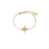 Gold bracelet with a mother of pearl and diamond flower on a white background