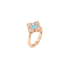 Rose gold flower ring with blue topaz center stone surrounded by pavé diamonds on smooth band.