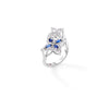 Side view of a white gold double floral bypass ring with diamonds and blue sapphires on a white background