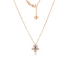 The Roberto Coin LOVE IN VERONA PAVE DIAMOND AND RUBELLITE SPLIT FLOWER NECKLACE features an 18K rose gold floral pendant with pavé diamonds and a central rubellite, shown with its matching chain and flower charm against a white background.