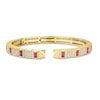 Yellow gold cuff bangle with pave diamond and ruby on a white background
