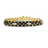 Gold bracelet with black enamel cobra pattern and embedded diamonds on a white background