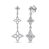 White gold triple flower dangle earrings with diamond accents on a white background