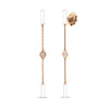 Rose gold dangle earrings with alternating white enamel bar and diamond bezel stations on a white background