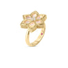 The VERNAZZA DIAMOND AND MOTHER OF PEARL FLOWER RING by Roberto Coin showcases an 18K yellow gold floral design with mother of pearl petals, sparkling diamond accents, and a textured gold band with a subtle touch of red inside.