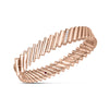 The DOMINO DIAMOND ACCENT BANGLE by Roberto Coin is a rose gold bangle with a zigzag, ridged design, set with three diamonds and a pink gemstone—an elegant accessory for any occasion.