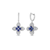 The LOVE IN VERONA Diamond and Blue Sapphire Flower Earrings by Roberto Coin feature 18K white gold, diamond-encrusted petals, and blue sapphire centers, beautifully displayed against a white background.