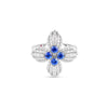 The LOVE IN VERONA DIAMOND AND BLUE SAPPHIRE FLOWER RING by Roberto Coin features four white gold petals encrusted with diamonds, accented with vivid blue sapphires at the center and tips—an exquisite floral design inspired by Love in Verona.